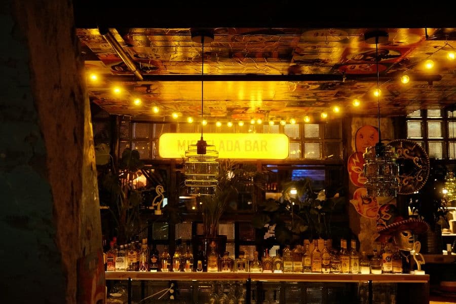 Barra de bar iluminada con botellas
